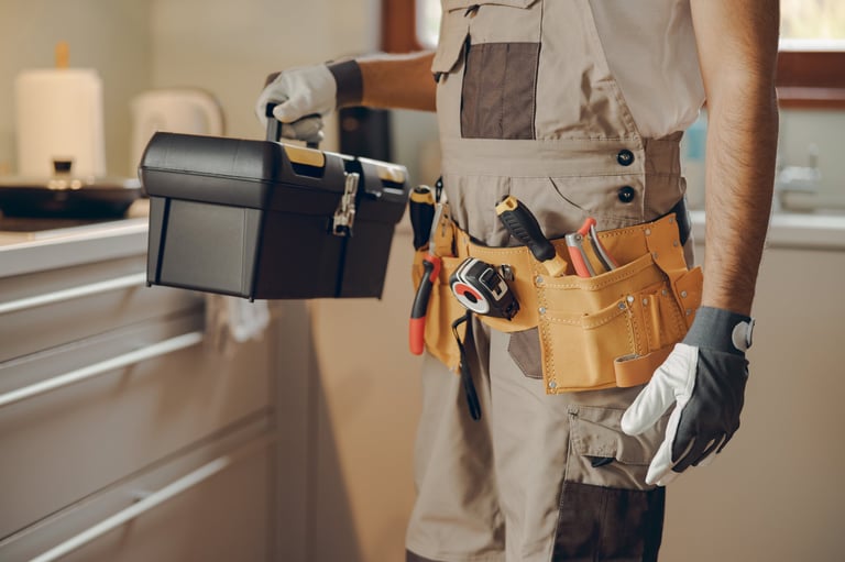Professional handyman with tool bag in home