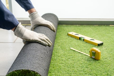Artificial turf being unrolled for cleaning