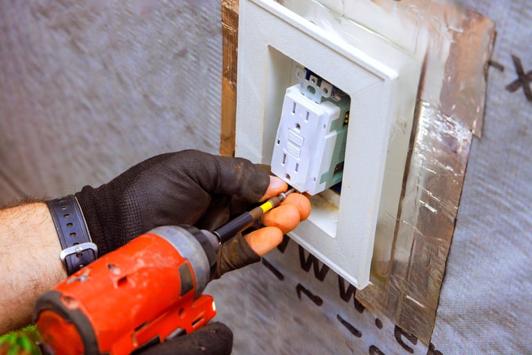 An electrician works on installing an electrical outlet in home