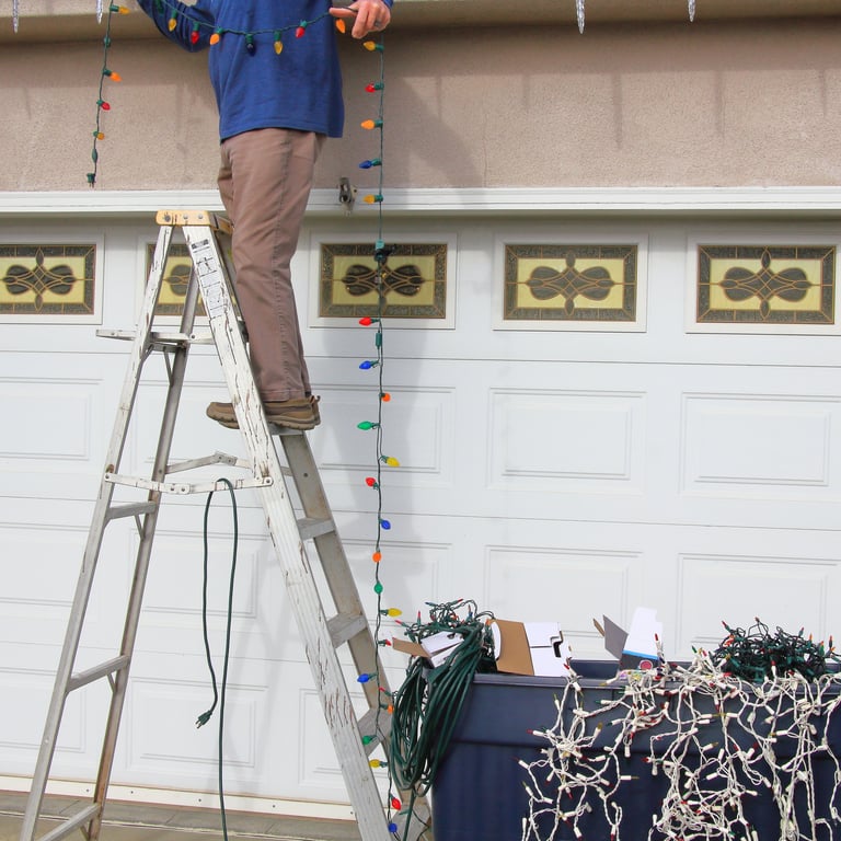 Professional installer on ladder hanging holiday lights