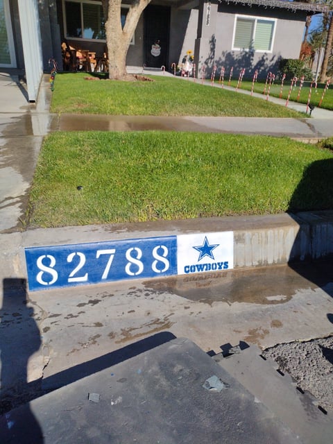 Residential house with green lawn and blue Cowboys mailbox displaying address 82788
