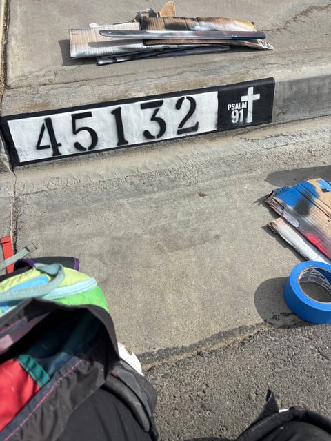 Evidence collection photo showing numbered scale 45132 with Psalm 91:1 marking, materials, and tape on concrete surface