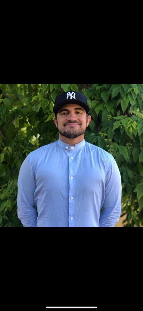 Matt Tallman, Co-Founder of Curb2Current, smiling in front of green foliage