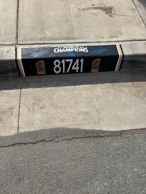 Los Angeles Dodgers Champions bumper sticker with number 81741 and World Series trophy logos on concrete ground