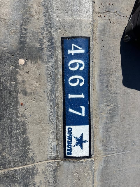 Blue and white address plaque mounted on concrete wall displaying the number 4661 with a star logo