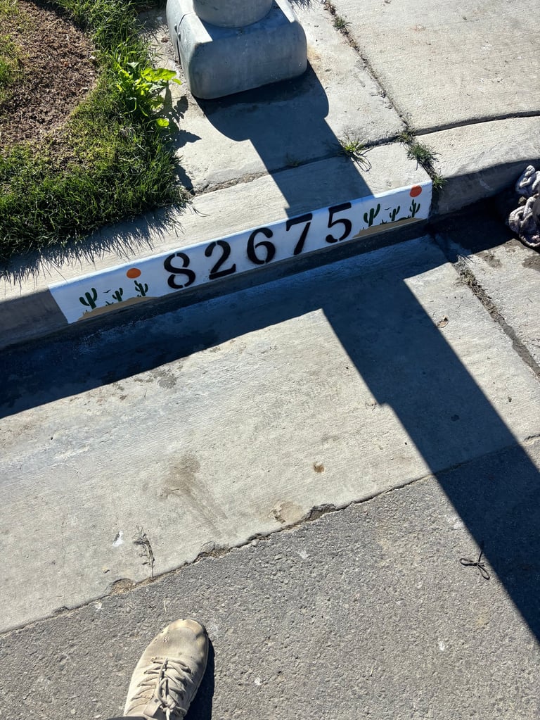 Overhead view of a measurement scale marked 82675 on concrete ground with shadows and a persons foot visible