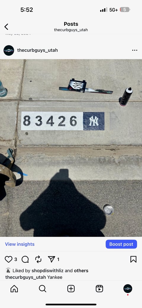 Overhead view of sidewalk with numbered marker 83426 and New York Yankees logo, measurement scale, and photography equipment