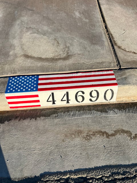 American flag label with number 44690 placed on weathered gray concrete surface