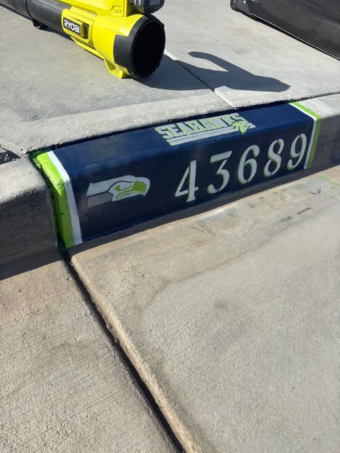 Yellow Ryobi power tool on concrete with dark blue garage door seal labeled 43689