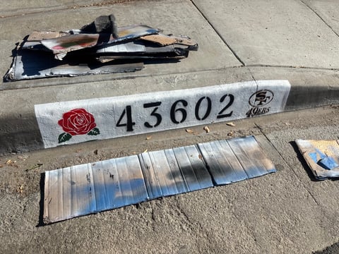 Car parts displayed on concrete with address number 43602 marker and Hyundai logo visible