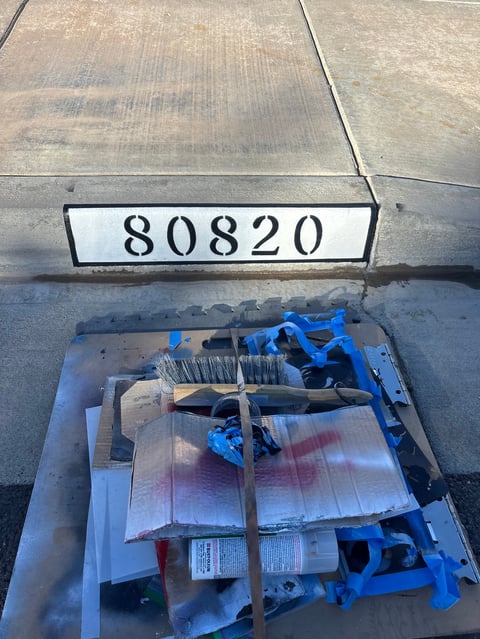 Industrial pallet labeled 80820 containing blue plastic parts, brushes, and packaged materials on concrete floor